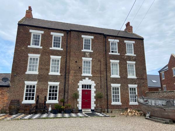Moonfleet Guest House exterior with red front door in Skinningrove